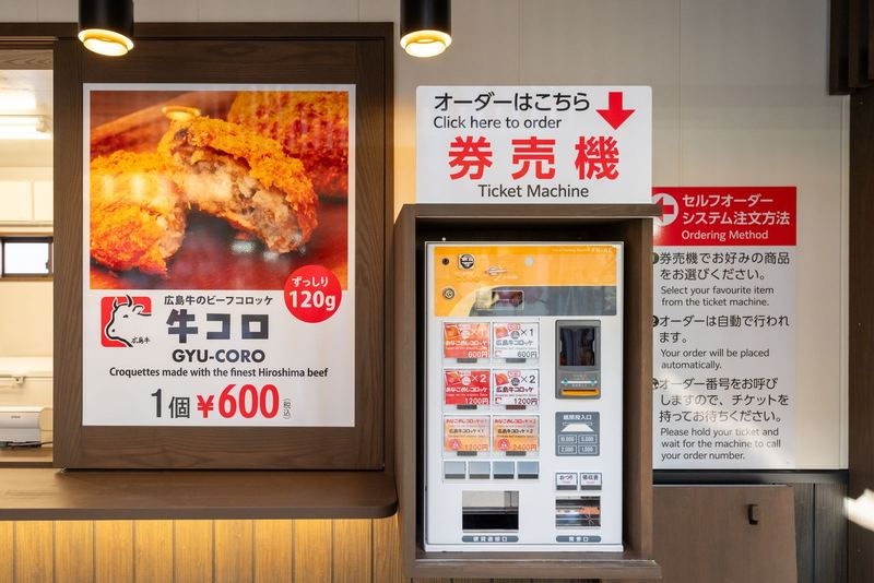 店頭の券売機と牛コロのポスター